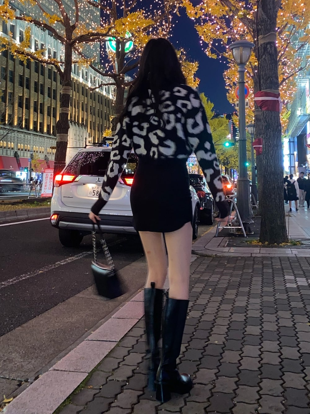 ブラック系のスカート、ブラック系のカーディガン/ボレロ、ブラック系のブーツを着用したレディースの冬コーディネートの3枚目の写真