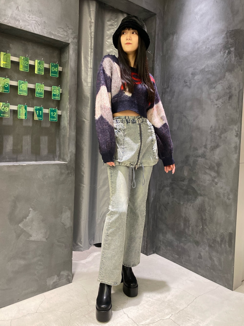 ブルー系のデニムパンツ、ブルー系のニット/セーター、ブラック系のブーツを着用したレディースの秋コーディネートの2枚目の写真