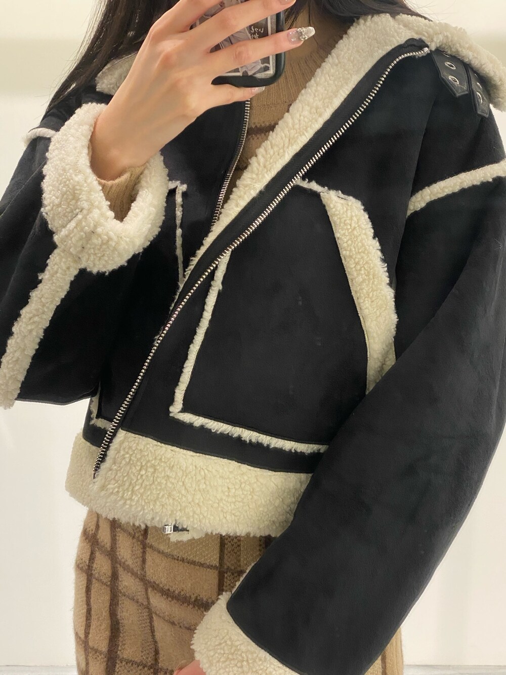 ベージュ系のスカート、ベージュ系のニット/セーター、ブラック系のブーツを着用したレディースの冬コーディネートの6枚目の写真