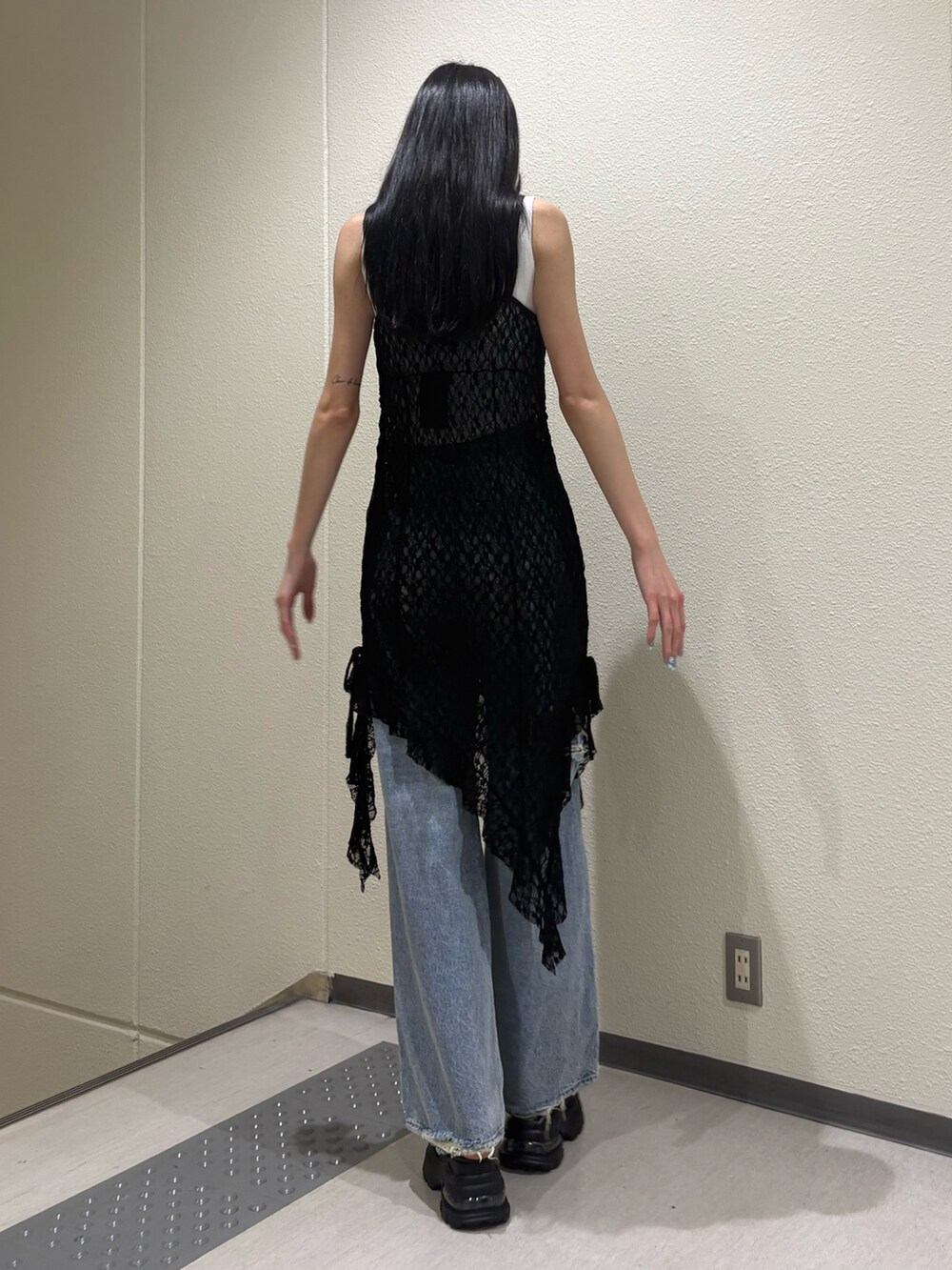 ホワイト系のニット/セーター、ブラック系のワンピース、ブルー系のデニムパンツを着用したレディースの夏コーディネートの5枚目の写真