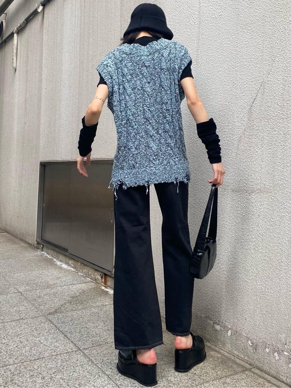 ブラック系のデニムパンツ、ブルー系のベスト、ブラック系のスリッポンを着用したレディースの夏コーディネートの4枚目の写真