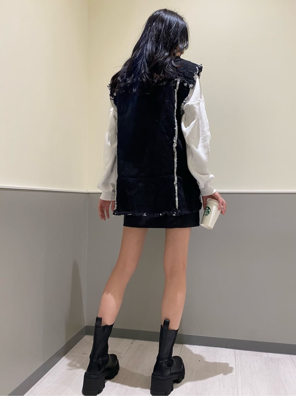 ブラック系のブーツ、ブラック系のデニムジャケット、ホワイト系のスウェットを着用したレディースの秋コーディネートの3枚目の写真