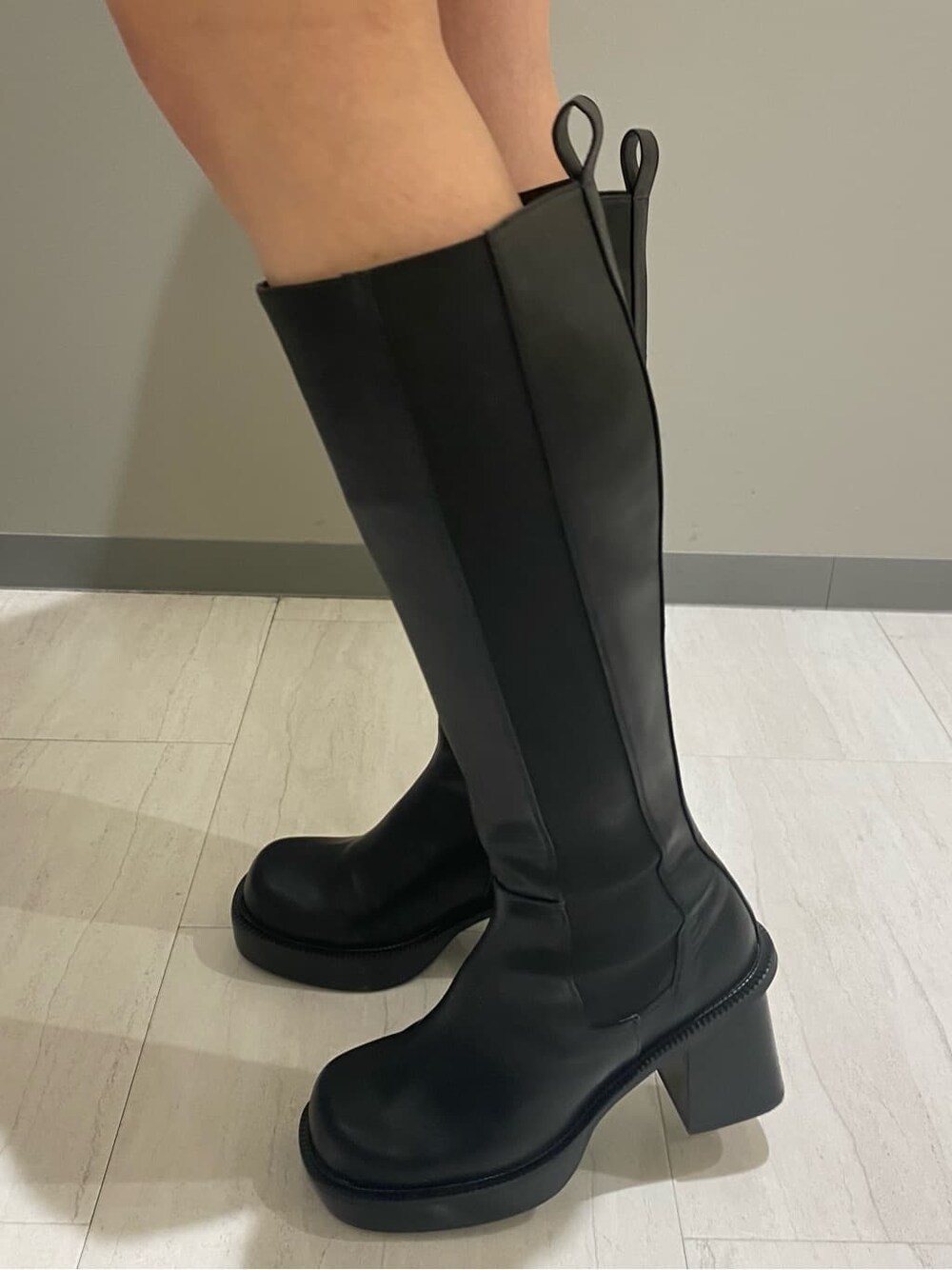 ブラック系のブーツ、ブラック系のスカート、ブルー系のニット/セーターを着用したレディースの秋コーディネートの7枚目の写真