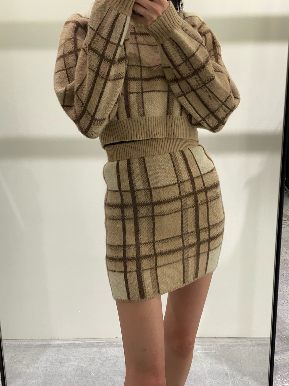 ベージュ系のニット/セーター、ベージュ系のスカート、ブラック系のブーツを着用したレディースの冬コーディネートの4枚目の写真