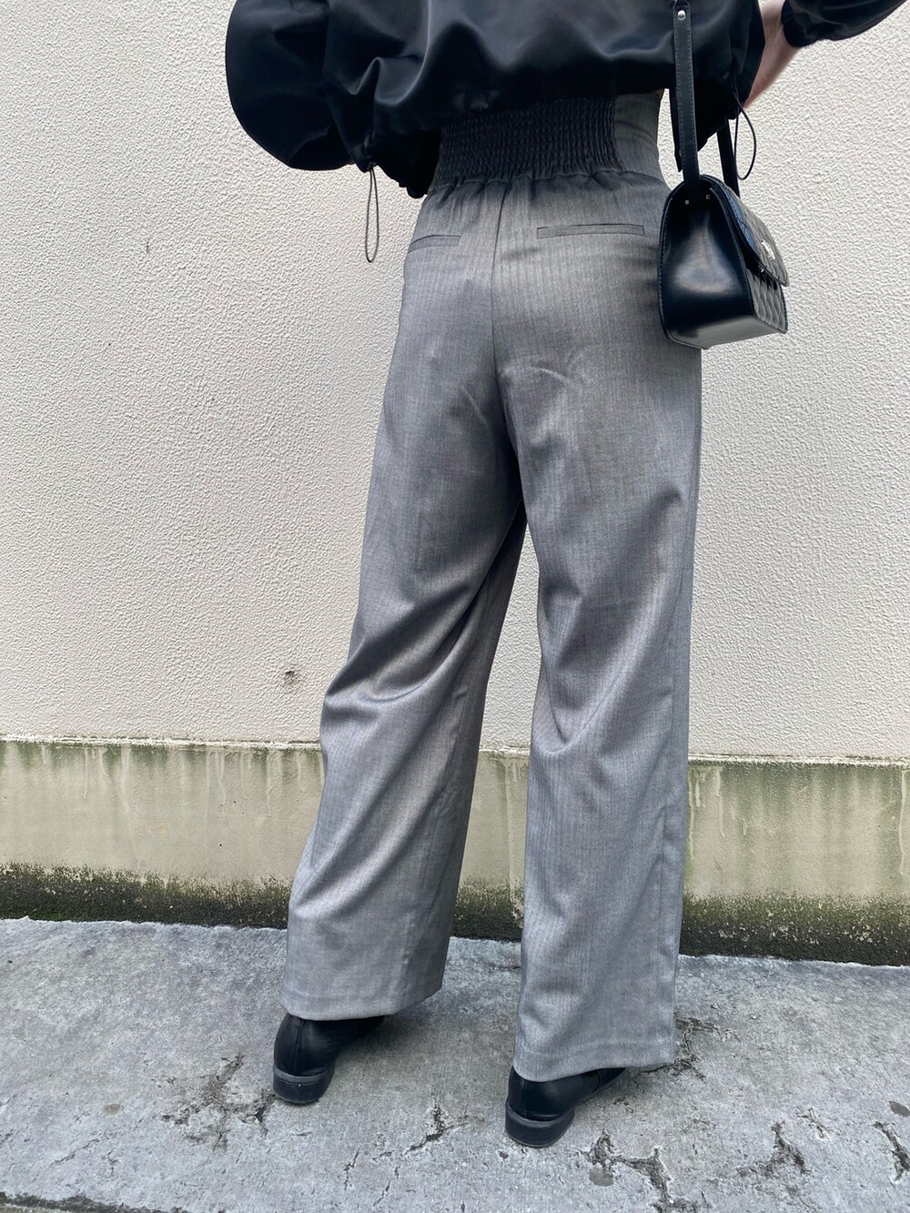 ブラック系のブルゾン、ブラック系のニット/セーター、グレー系のその他パンツを着用したレディースの冬コーディネートの7枚目の写真