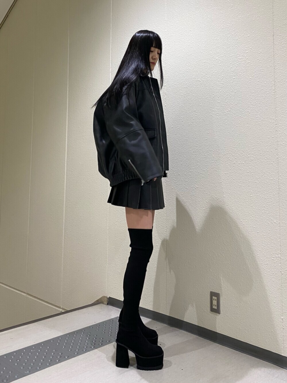 ブラック系のスカート、その他のニット/セーター、ブラック系のブーツを着用したレディースの冬コーディネートの5枚目の写真