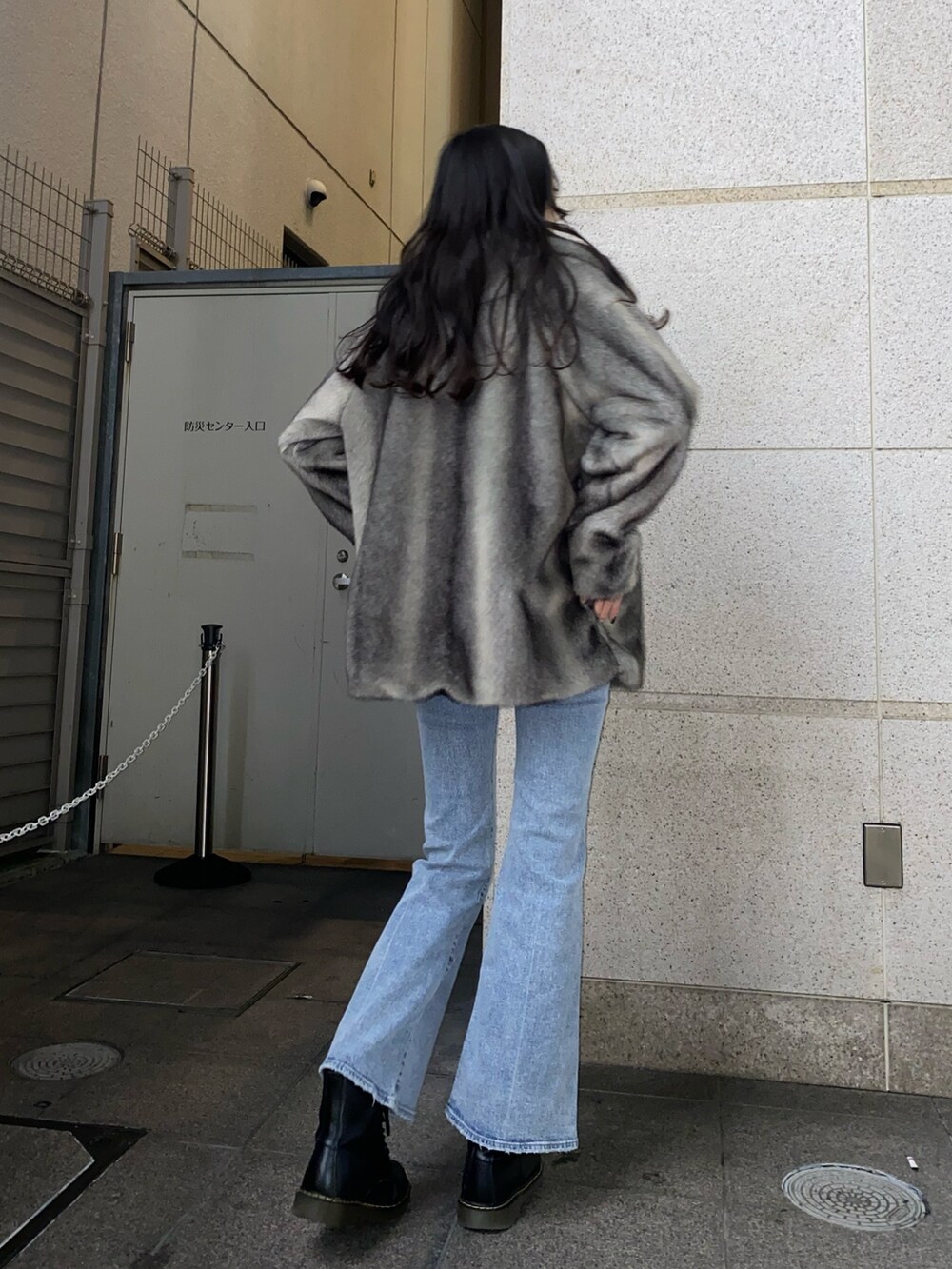 ブラック系のニット/セーター、グレー系のその他アウター、ブルー系のデニムパンツを着用したレディースの冬コーディネートの3枚目の写真