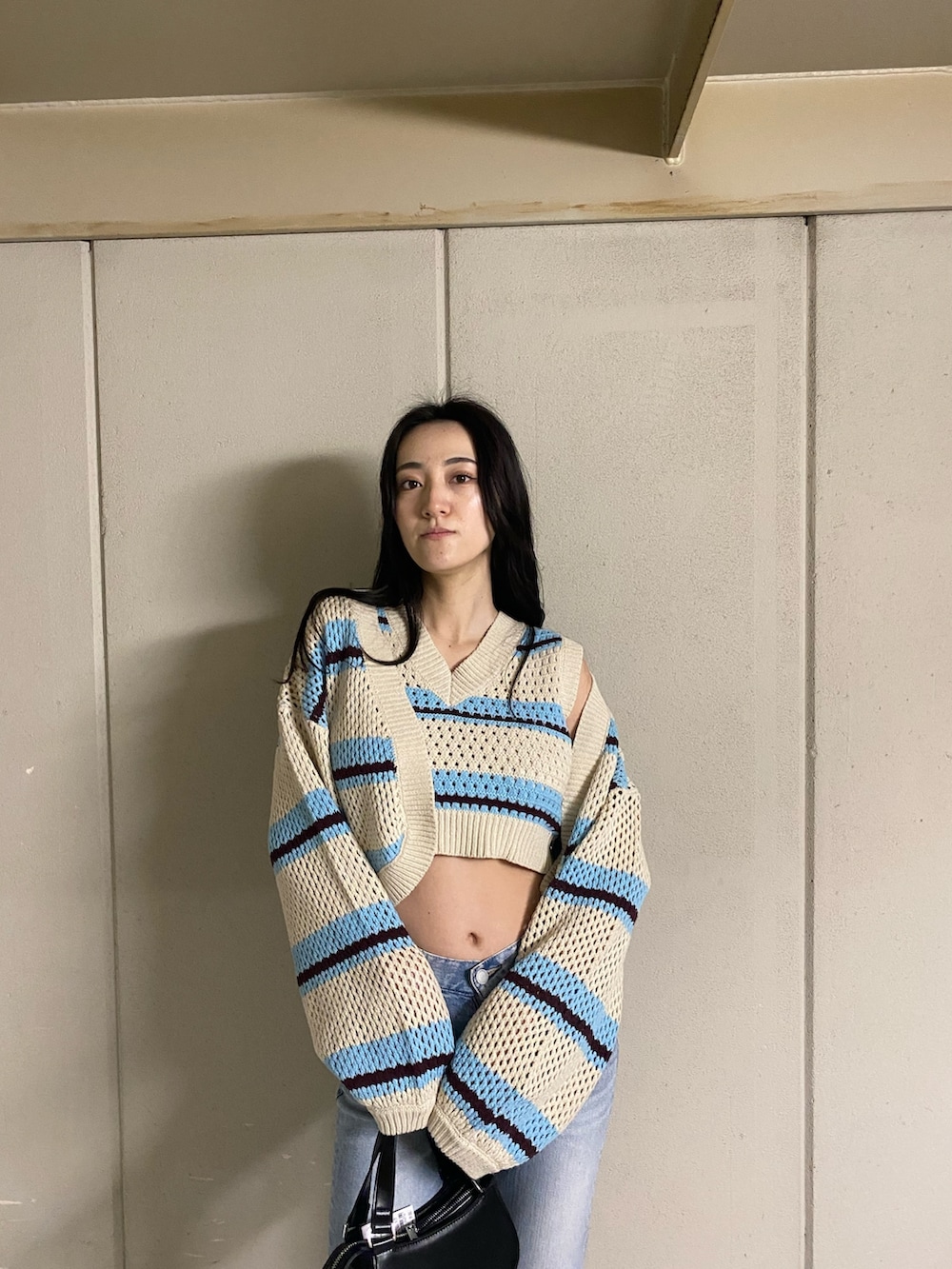 その他のニット/セーター、ブルー系のデニムパンツ、ブラック系のハンドバッグを着用したレディースの春コーディネートの5枚目の写真