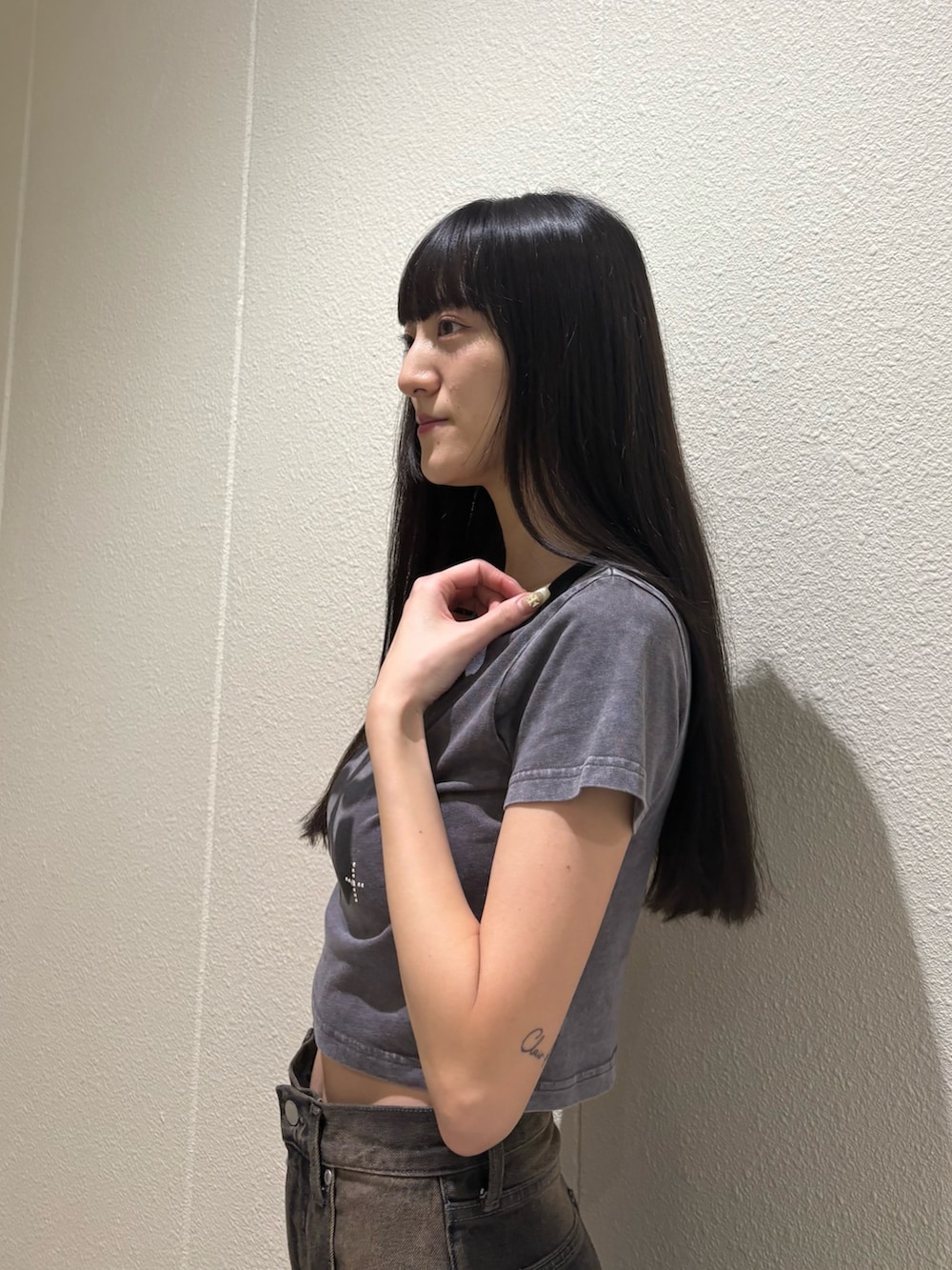 ブラック系のデニムパンツ、ブラック系のサンダル、グレー系のTシャツ/カットソーを着用したレディースの夏コーディネートの6枚目の写真