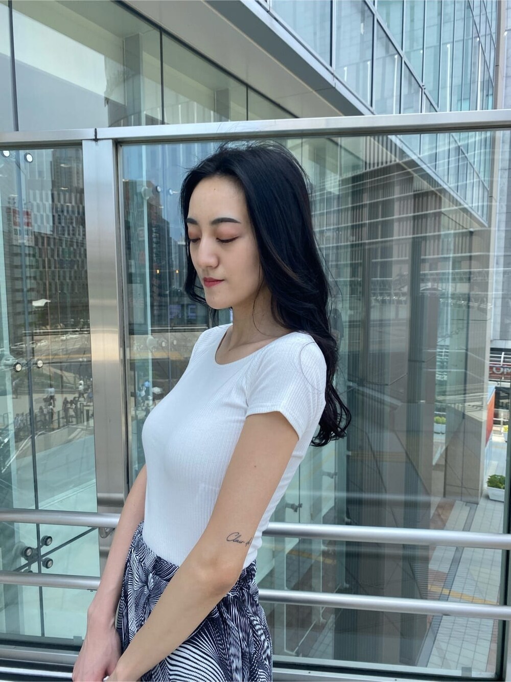 ブラック系のサンダル、ブラック系のハンドバッグ、その他のスカートを着用したレディースの夏コーディネートの7枚目の写真