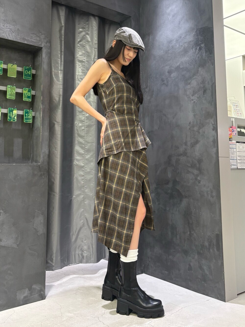 グリーン系のワンピース、ブラック系のブーツ、グレー系のハンチング/ベレー帽を着用したレディースの夏コーディネートの4枚目の写真