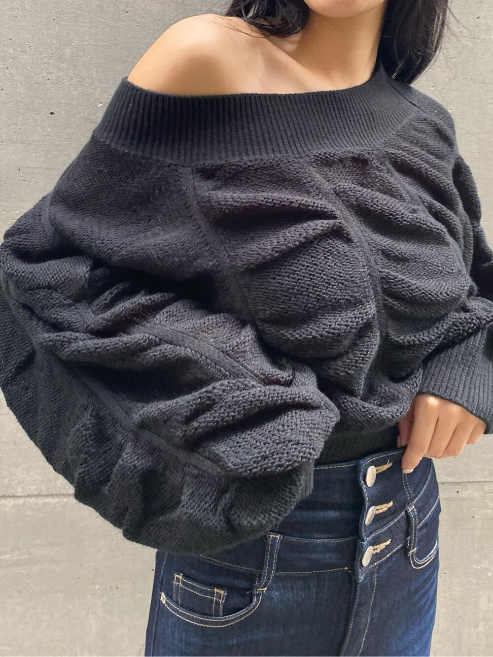 ブラック系のパンプス、ブルー系のデニムパンツ、ブラック系のニット/セーターを着用したレディースの秋コーディネートの4枚目の写真