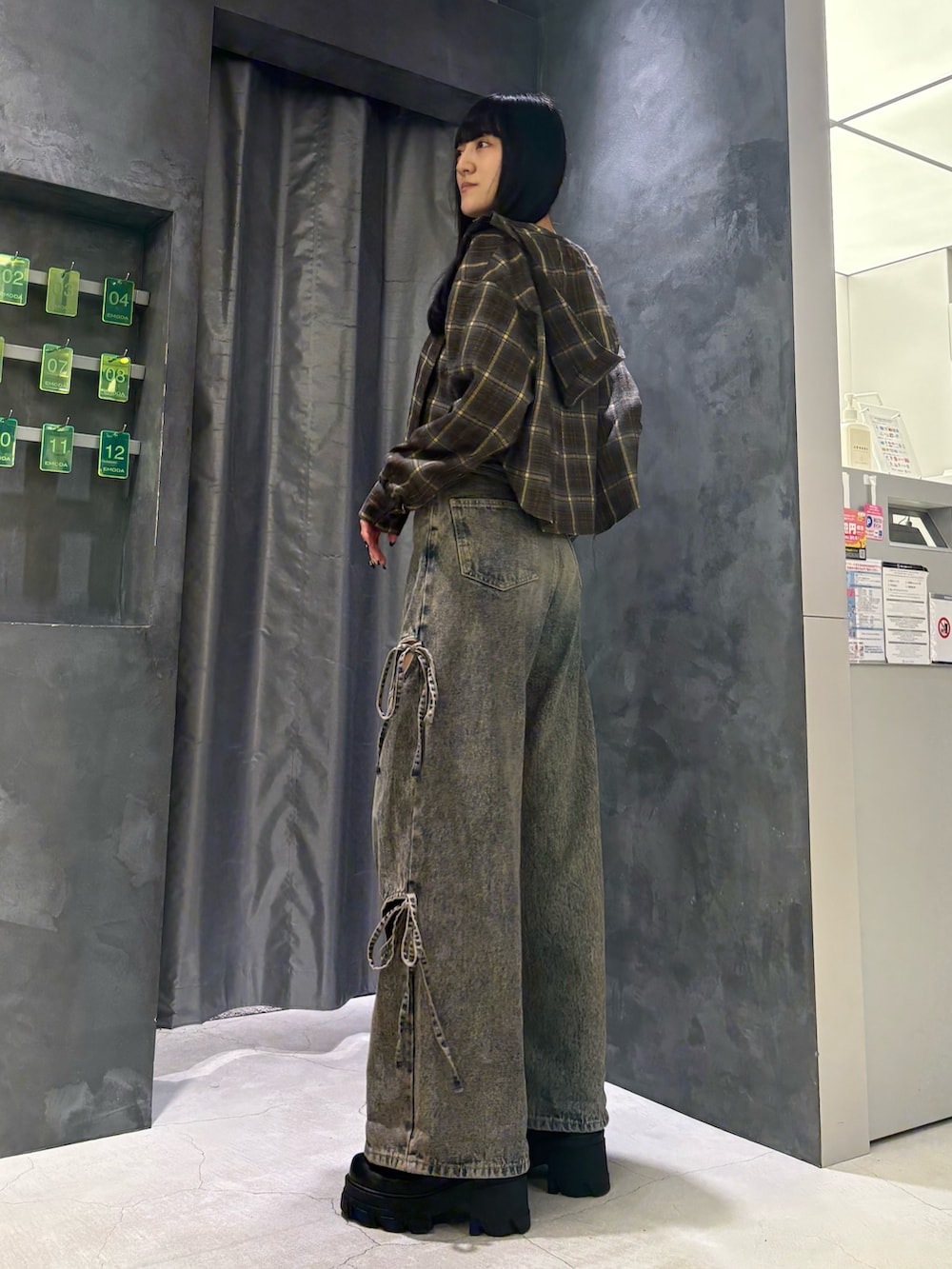 ブルー系のデニムパンツ、ブラック系のブーツ、グリーン系のシャツ/ブラウスを着用したレディースの夏コーディネートの3枚目の写真