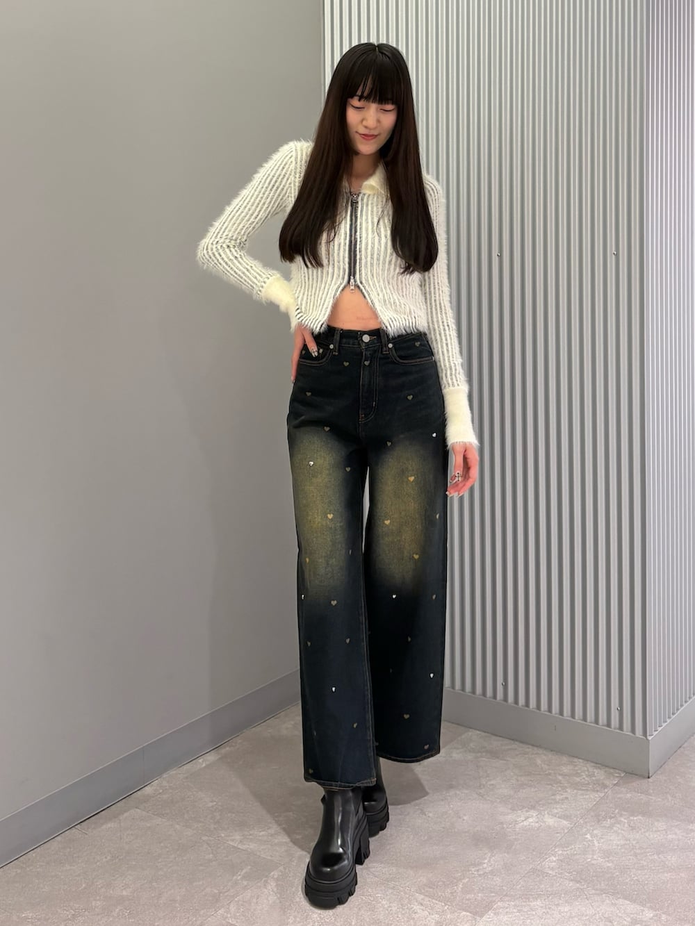 ブルー系のデニムパンツ、ホワイト系のニット/セーター、ブラック系のブーツを着用したレディースの秋コーディネートの5枚目の写真