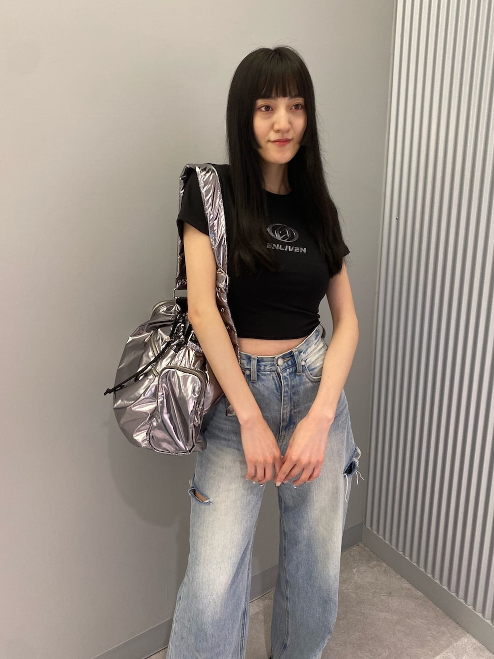 ブラック系のTシャツ/カットソー、ブラック系のサンダル、ブルー系のデニムパンツを着用したレディースの夏コーディネートの6枚目の写真