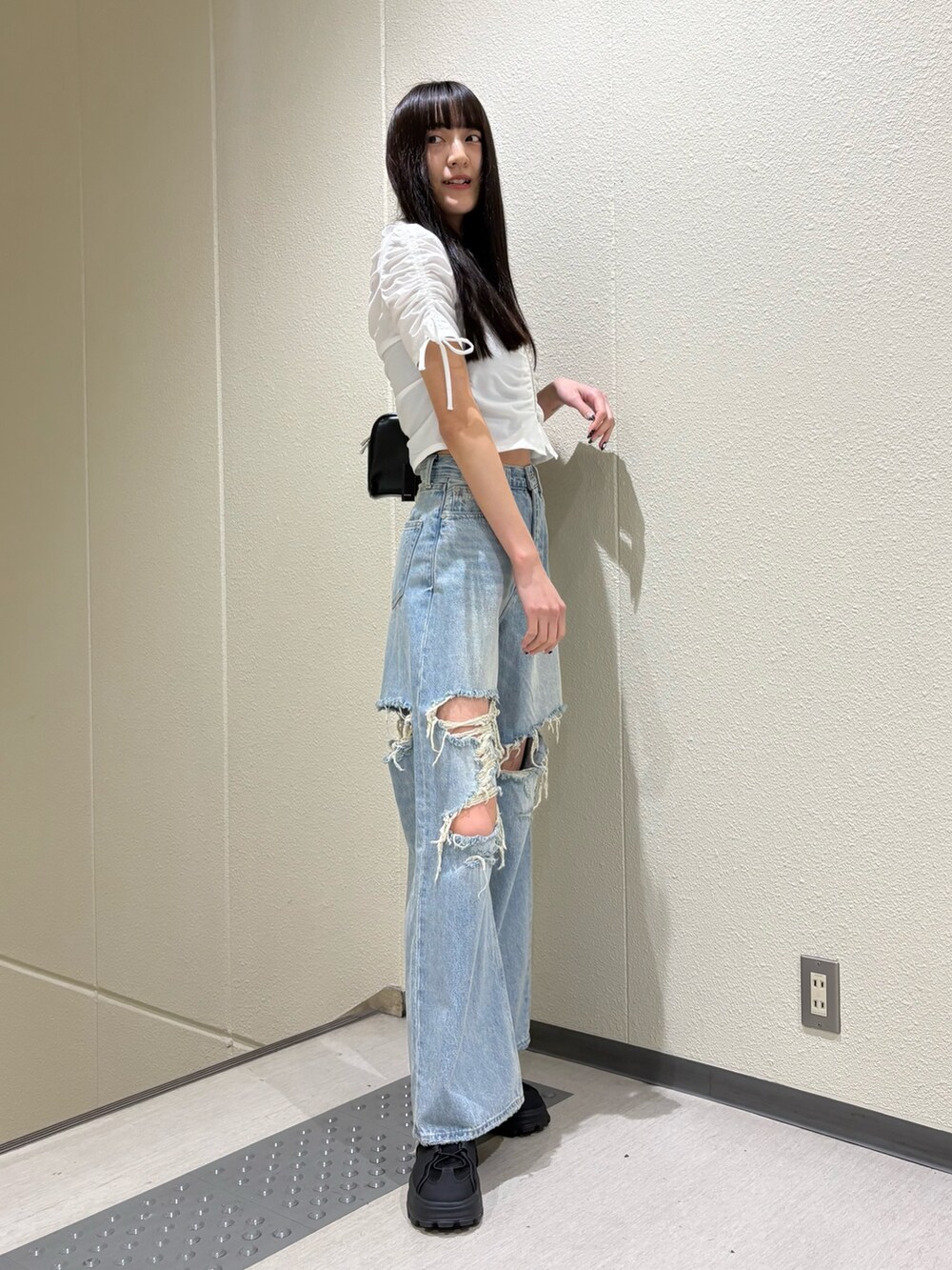 ブルー系のデニムパンツ、ホワイト系のシャツ/ブラウス、ブラック系のサンダルを着用したレディースの春コーディネートの5枚目の写真