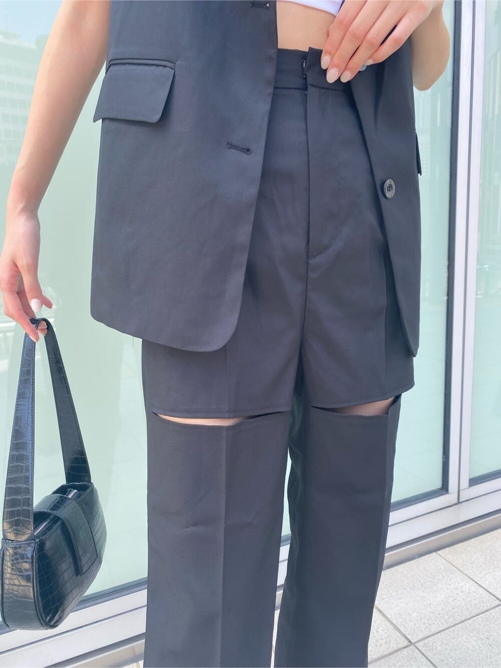 ホワイト系のスニーカー、ブラック系のベスト、ブラック系のその他パンツを着用したレディースの夏コーディネートの7枚目の写真