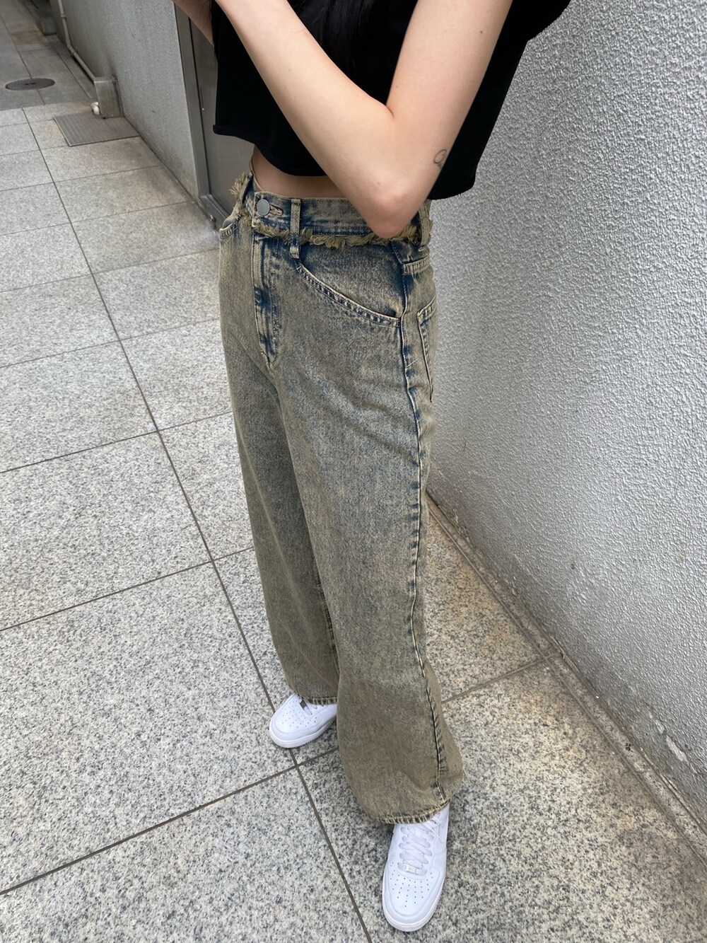 ブラック系のTシャツ/カットソー、ブラック系のハンドバッグ、ベージュ系のデニムパンツを着用したレディースの夏コーディネートの9枚目の写真