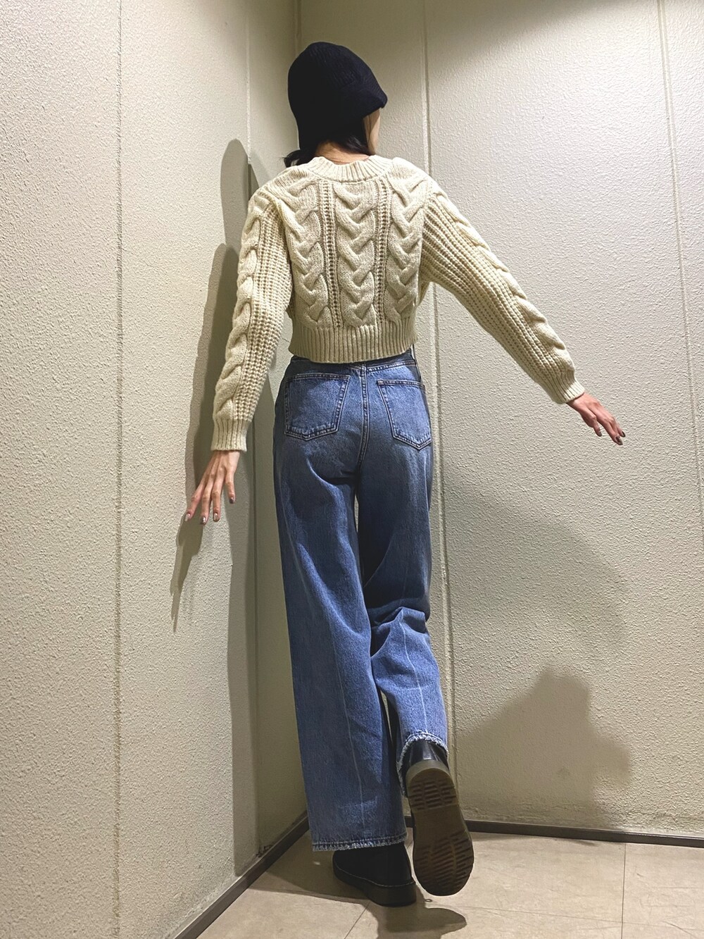 ブルー系のデニムパンツ、ホワイト系のカーディガン/ボレロ、ブラック系のハットを着用したレディースの秋コーディネートの3枚目の写真