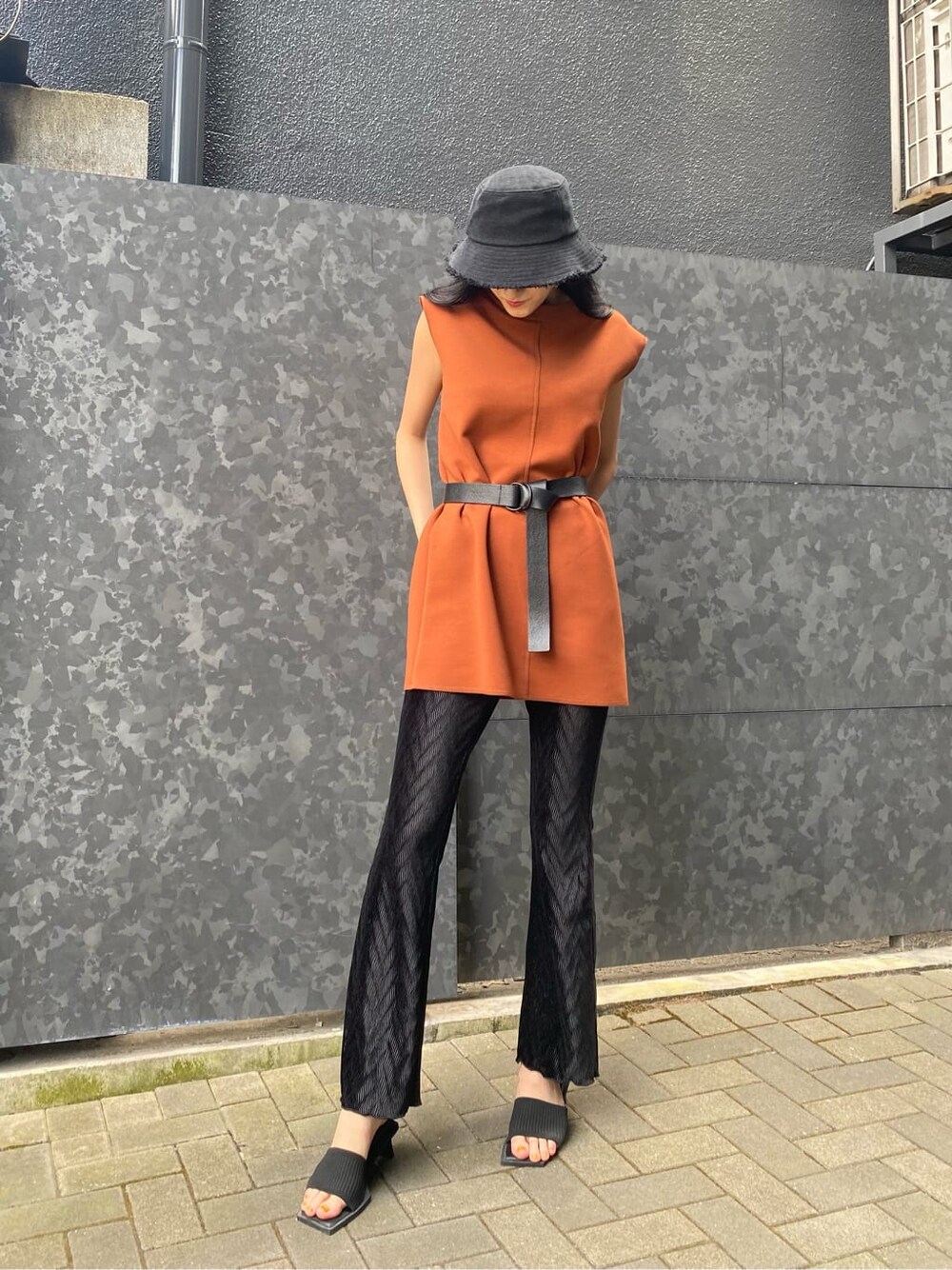 ブラック系のサンダル、オレンジ系のワンピース、ブラック系のその他パンツを着用したレディースの夏コーディネートの2枚目の写真