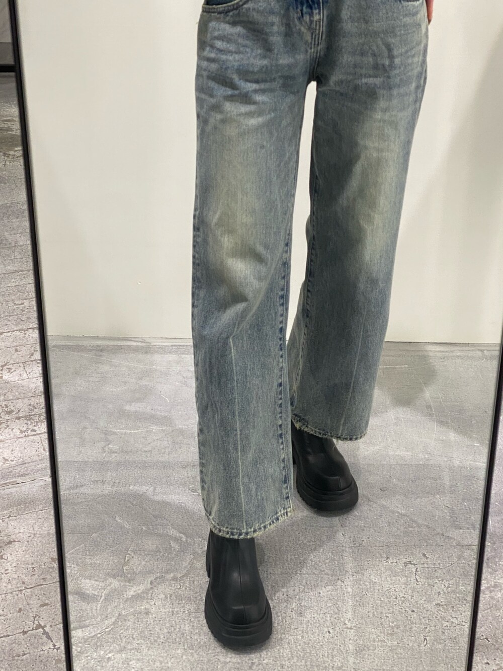 ブルー系のデニムパンツ、ブラック系のニット/セーター、ブラック系のブーツを着用したレディースの冬コーディネートの6枚目の写真