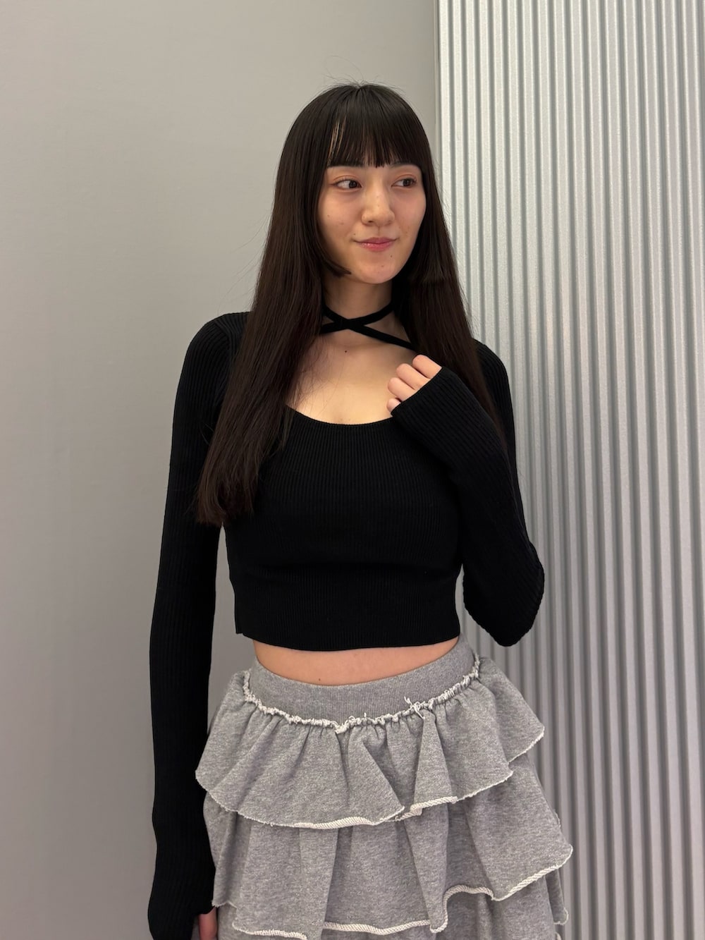 グレー系のスカート、ブラック系のニット/セーター、ブラック系のブーツを着用したレディースの秋コーディネートの6枚目の写真