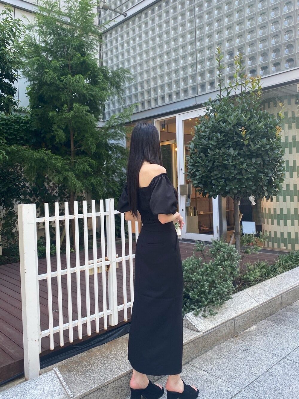 ブラック系のスカート、ブラック系のTシャツ/カットソー、シルバー系のネックレスを着用したレディースの夏コーディネートの4枚目の写真