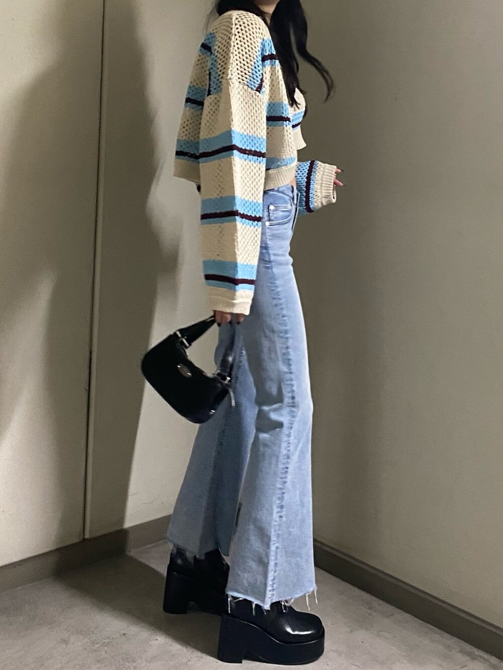 その他のニット/セーター、ブルー系のデニムパンツ、ブラック系のハンドバッグを着用したレディースの春コーディネートの3枚目の写真