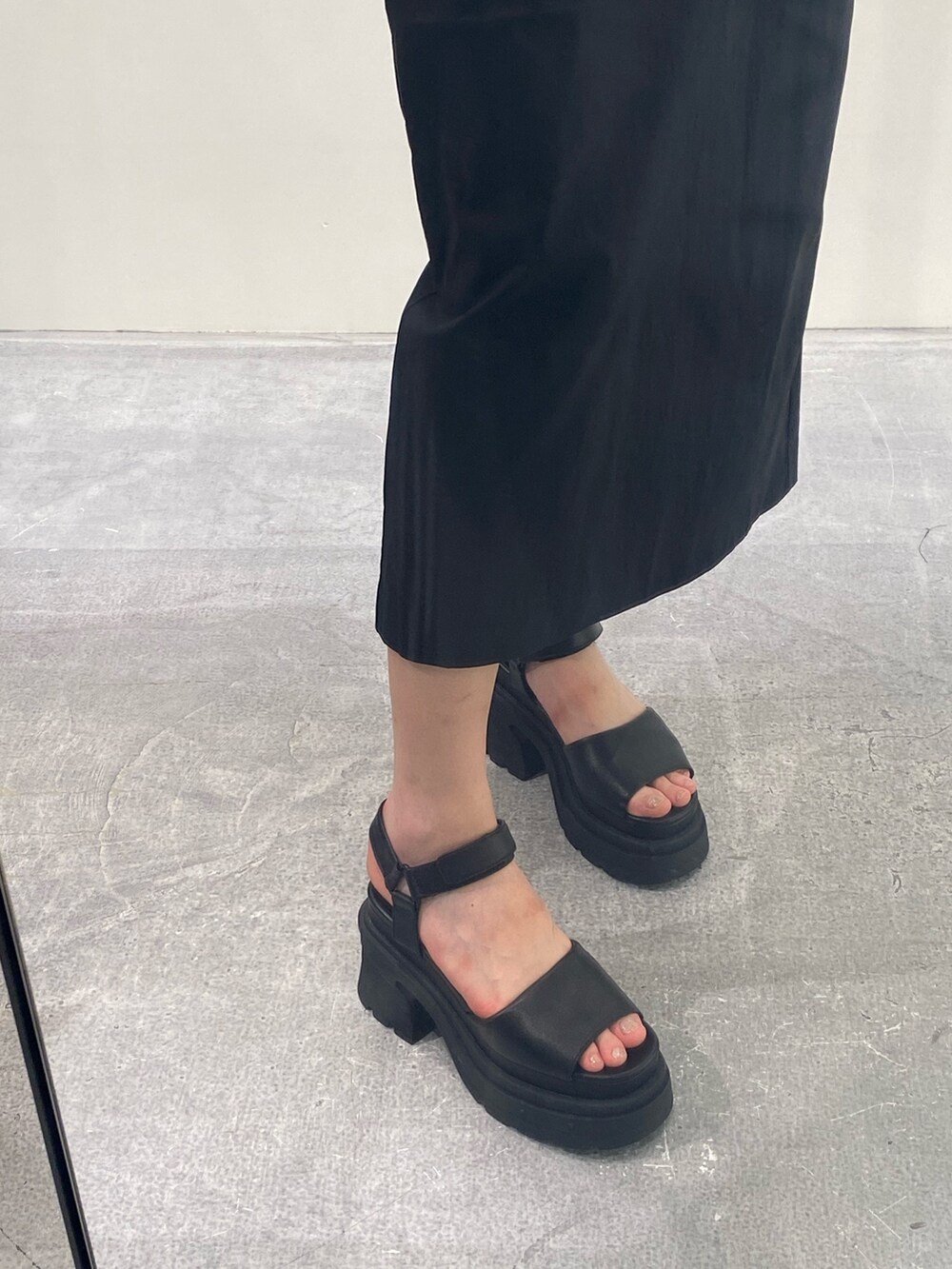 ブラック系のワンピース、ブラック系のサンダル、シルバー系のネックレスを着用したレディースの夏コーディネートの7枚目の写真