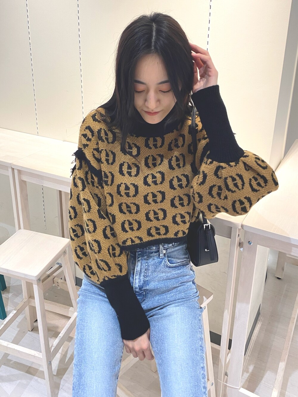 ブルー系のデニムパンツ、その他のニット/セーター、ブラック系のショルダーバッグを着用したレディースの秋コーディネートの5枚目の写真