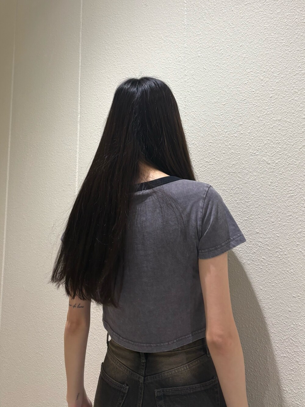 ブラック系のデニムパンツ、ブラック系のサンダル、グレー系のTシャツ/カットソーを着用したレディースの夏コーディネートの7枚目の写真