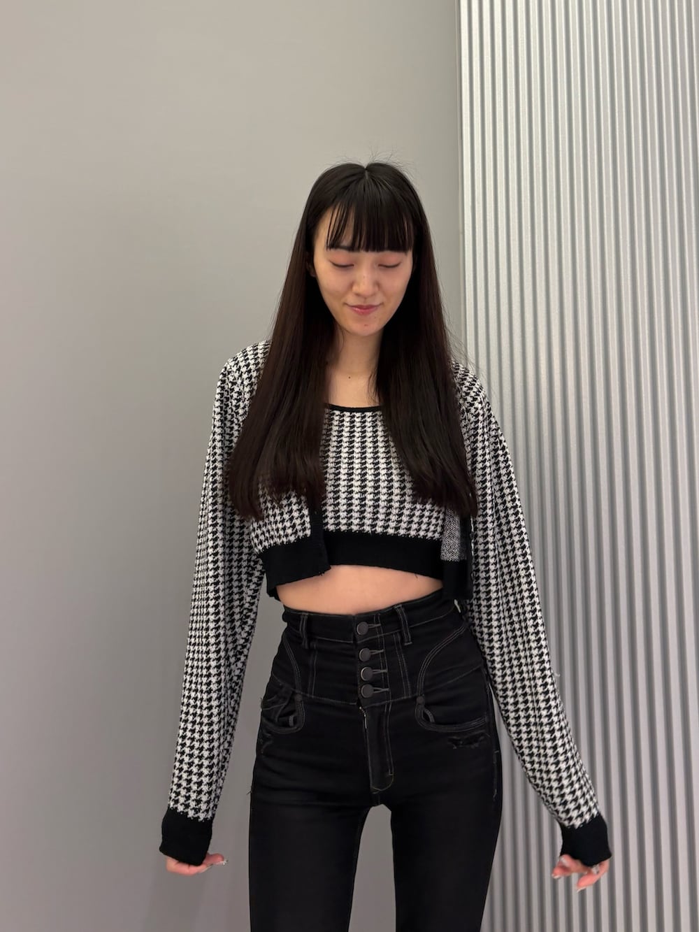 ブラック系のデニムパンツ、ブラック系のニット/セーター、ブラック系のブーツを着用したレディースの秋コーディネートの7枚目の写真