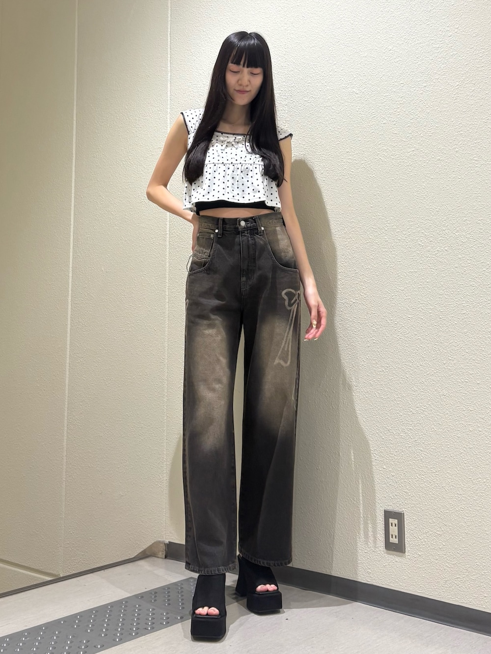 ブラック系のデニムパンツ、ホワイト系のタンクトップ、ブラック系のTシャツ/カットソーを着用したレディースの夏コーディネートの2枚目の写真