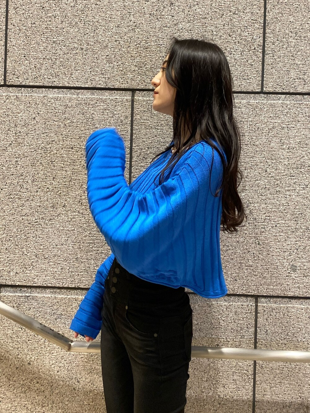 ホワイト系のブルゾン、ブルー系のニット/セーター、ブラック系のデニムパンツを着用したレディースの冬コーディネートの8枚目の写真