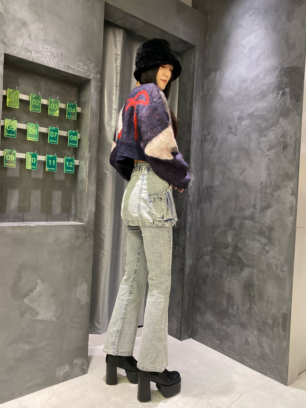 ブルー系のデニムパンツ、ブルー系のニット/セーター、ブラック系のブーツを着用したレディースの秋コーディネートの4枚目の写真