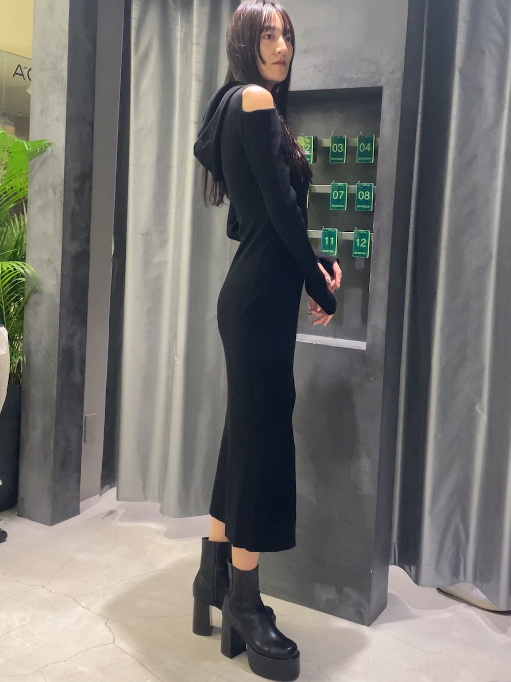 ブラック系のワンピース、ブラック系のブーツを着用したレディースの秋コーディネートの5枚目の写真