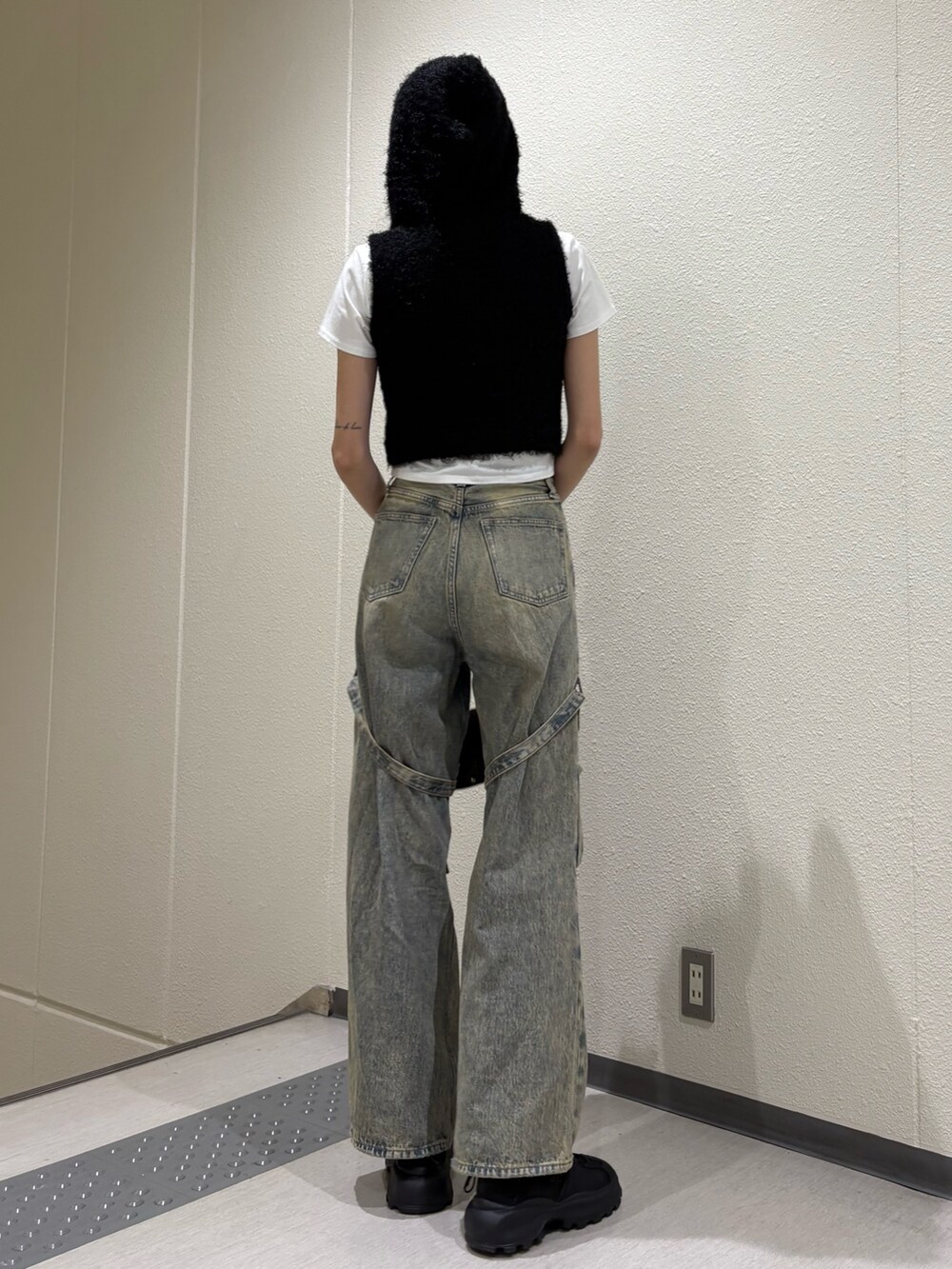 ブルー系のデニムパンツ、ブラック系のハンドバッグ、ホワイト系のTシャツ/カットソーを着用したレディースの春コーディネートの4枚目の写真