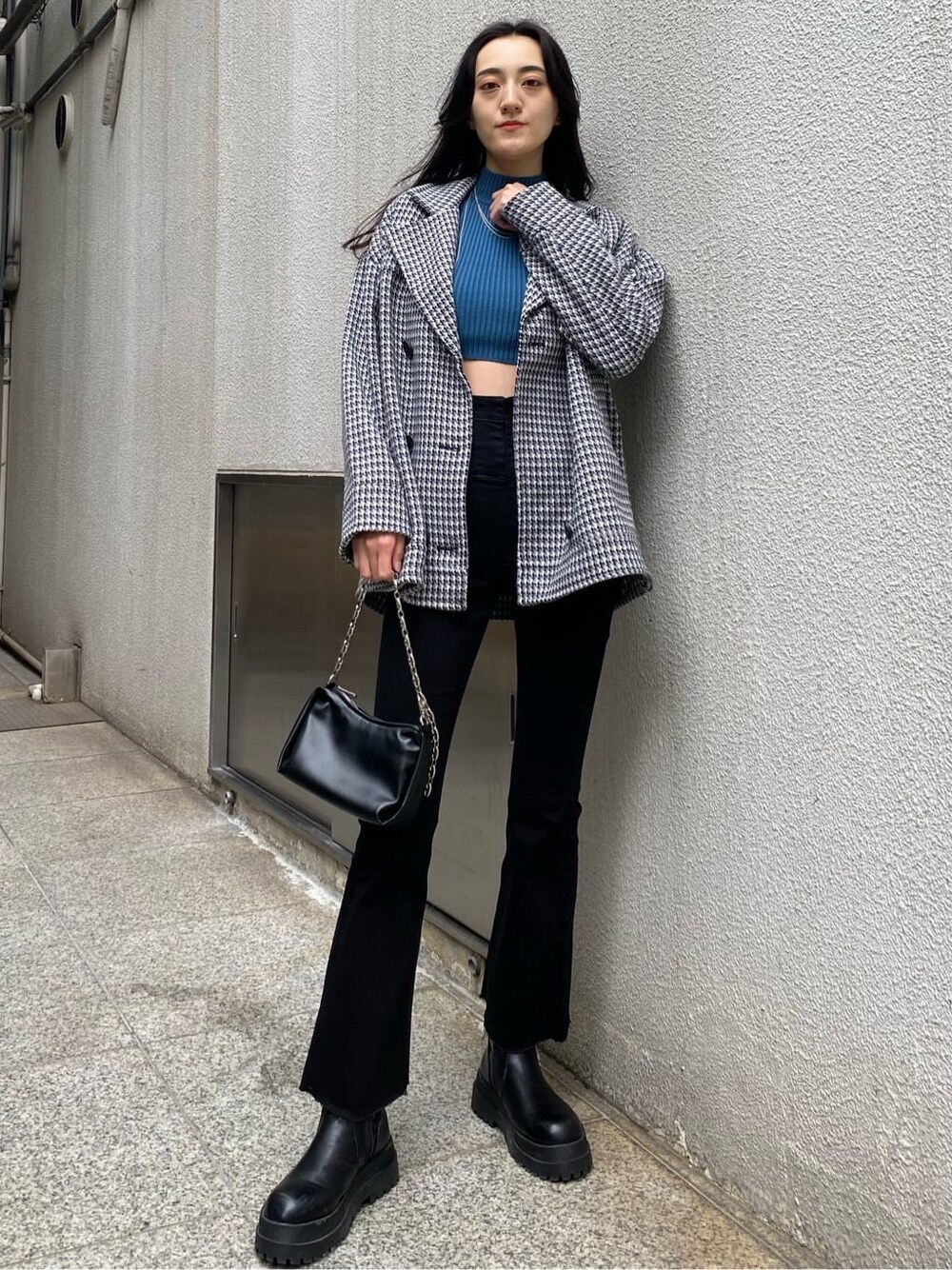 その他のテーラードジャケット、ブルー系のニット/セーター、ブラック系のハンドバッグを着用したレディースの秋コーディネートの2枚目の写真