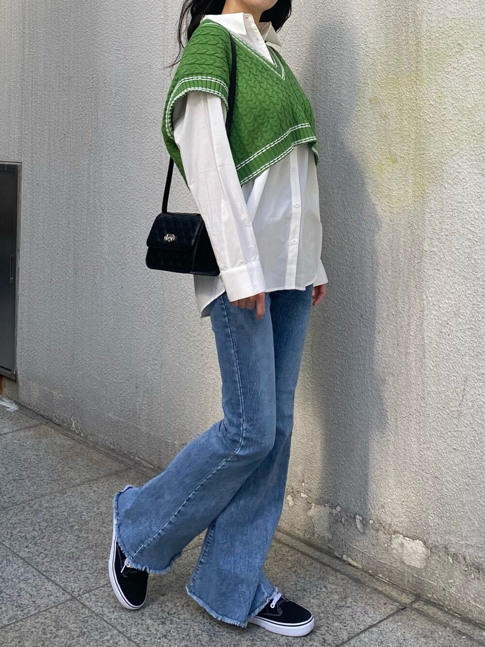 グリーン系のベスト、ホワイト系のシャツ/ブラウス、ブラック系のショルダーバッグを着用したレディースの冬コーディネートの3枚目の写真