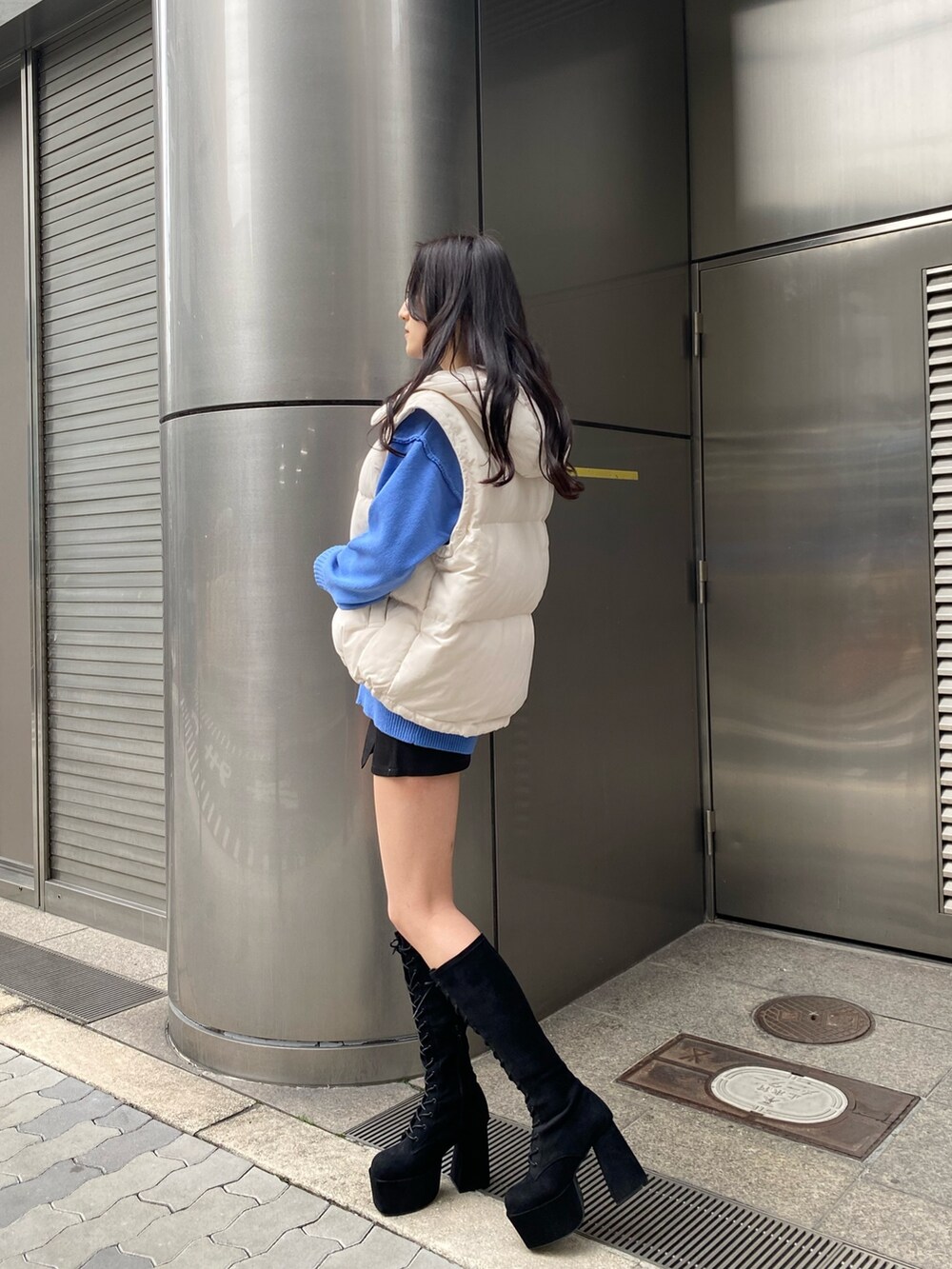 ブルー系のニット/セーター、ホワイト系のダウンジャケット/コート、ブラック系のスカートを着用したレディースの冬コーディネートの3枚目の写真