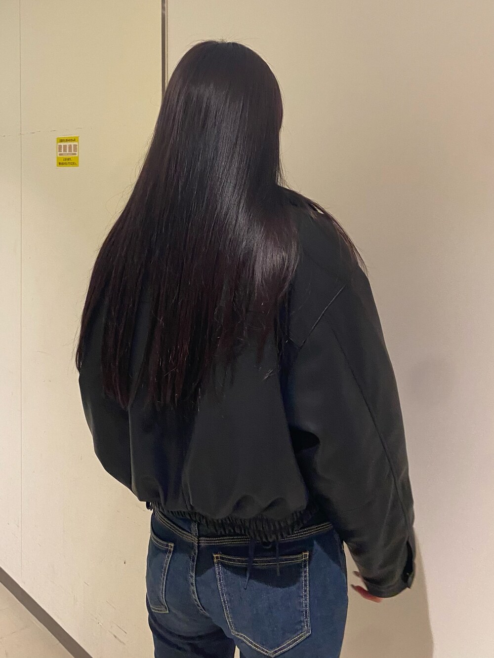 ブルー系のデニムパンツ、ホワイト系のニット/セーター、ブラック系のブルゾンを着用したレディースの秋コーディネートの6枚目の写真