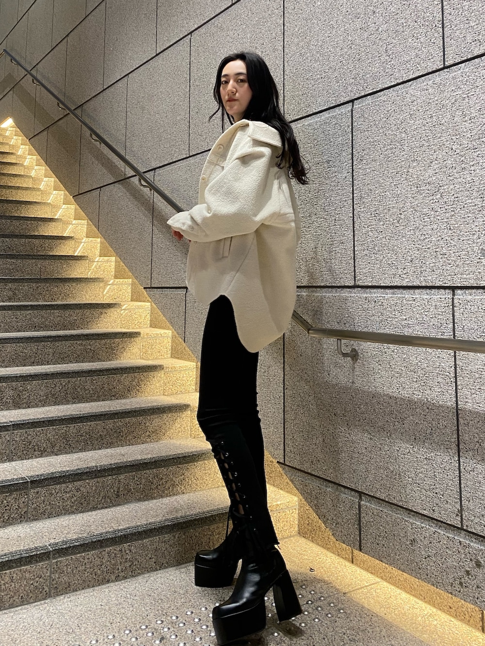 ホワイト系のブルゾン、ブルー系のニット/セーター、ブラック系のデニムパンツを着用したレディースの冬コーディネートの3枚目の写真