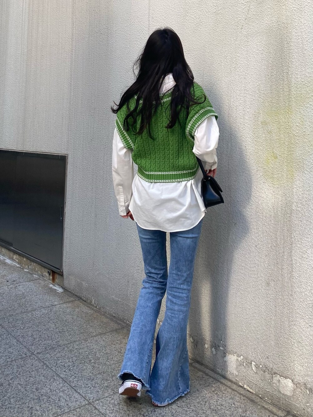 グリーン系のベスト、ホワイト系のシャツ/ブラウス、ブラック系のショルダーバッグを着用したレディースの冬コーディネートの2枚目の写真