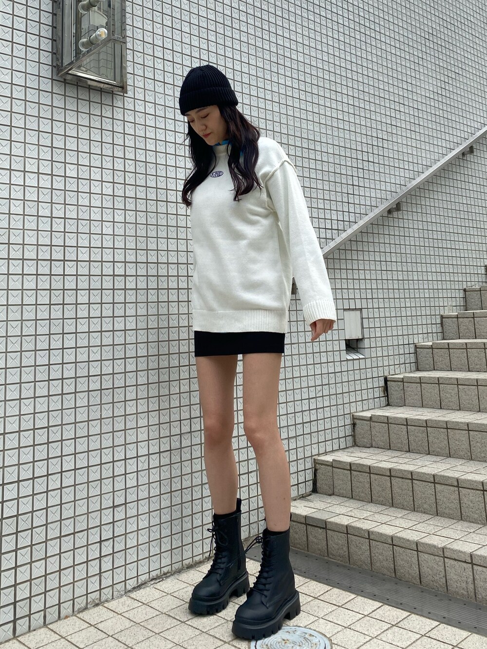 ブルー系のシャツ/ブラウス、ホワイト系のニット/セーター、ブラック系のスカートを着用したレディースの冬コーディネートの3枚目の写真