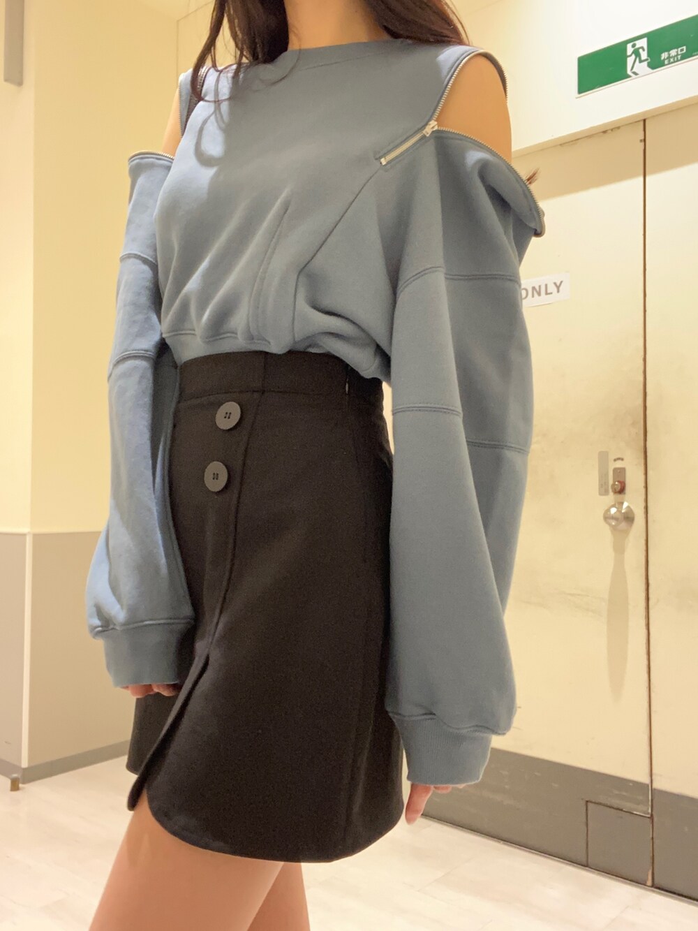 ブラック系のスカート、ブルー系のTシャツ/カットソー、ブラック系のショルダーバッグを着用したレディースの秋コーディネートの5枚目の写真