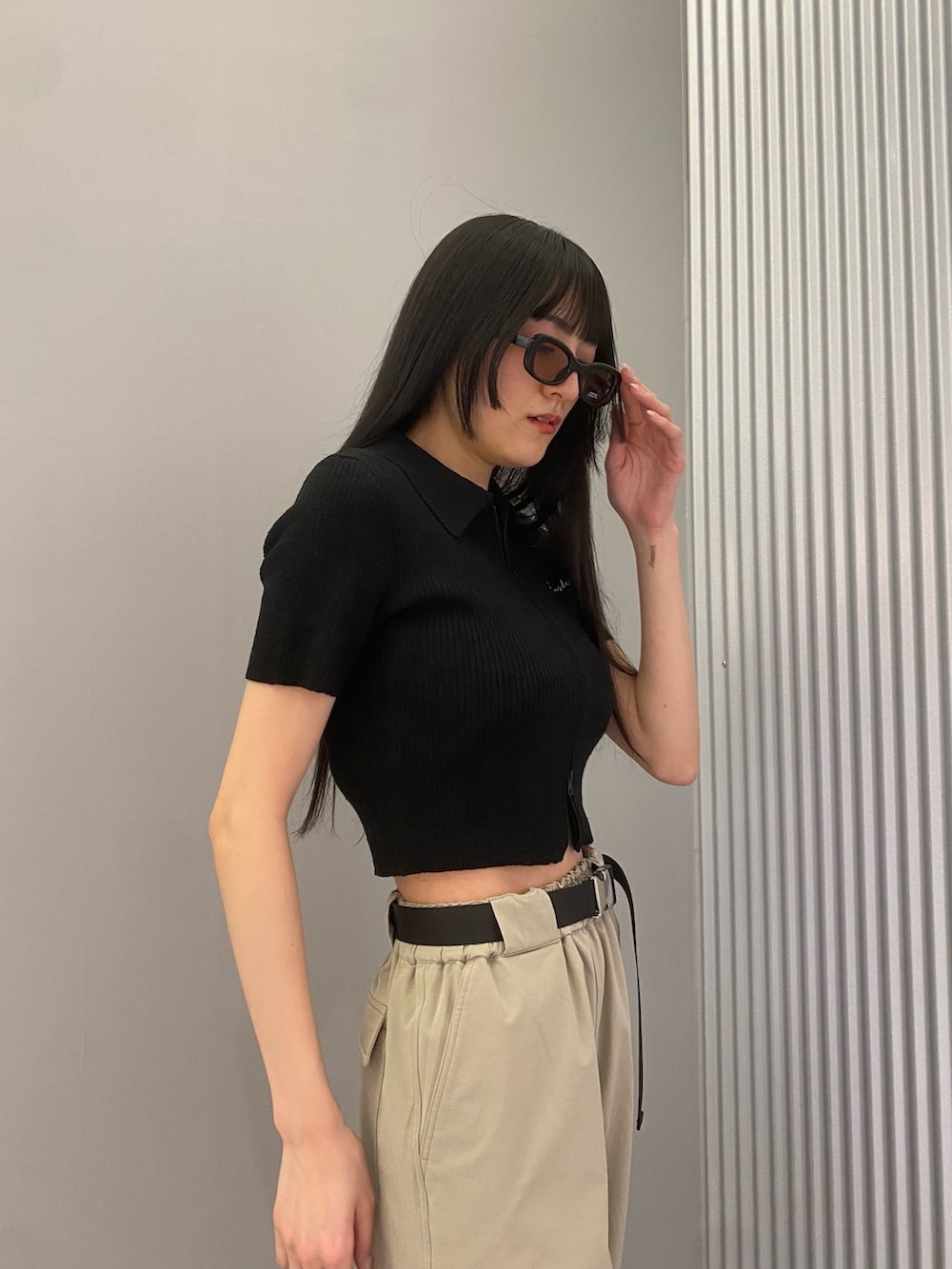 ベージュ系のカーゴパンツ、ブラック系のニット/セーター、ブラック系のブーツを着用したレディースの春コーディネートの6枚目の写真