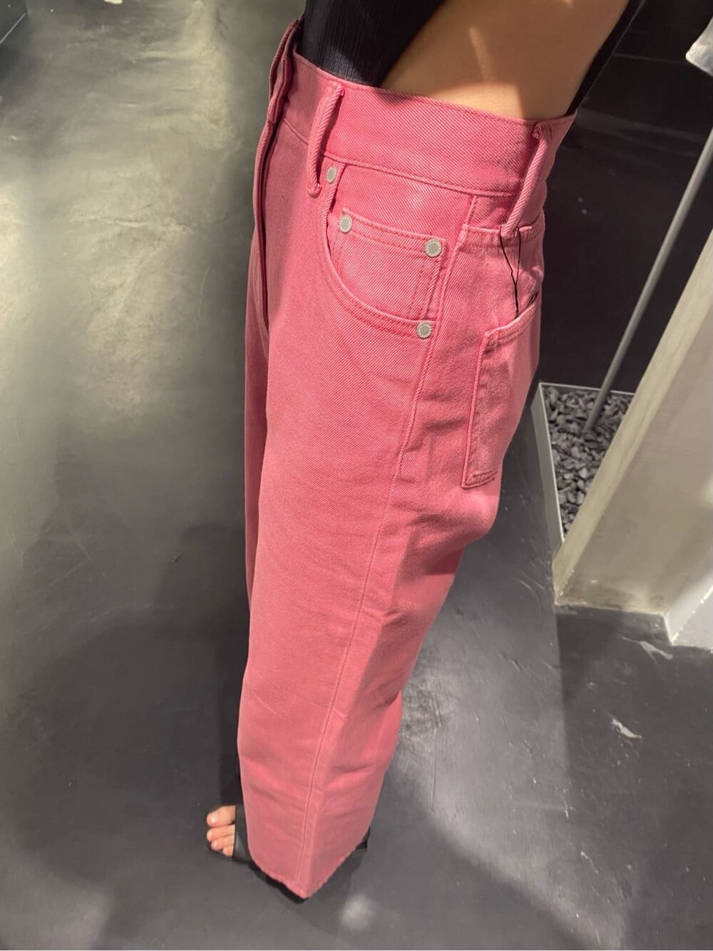 ピンク系のデニムパンツ、ブラック系のTシャツ/カットソー、ブラック系のハットを着用したレディースの夏コーディネートの3枚目の写真