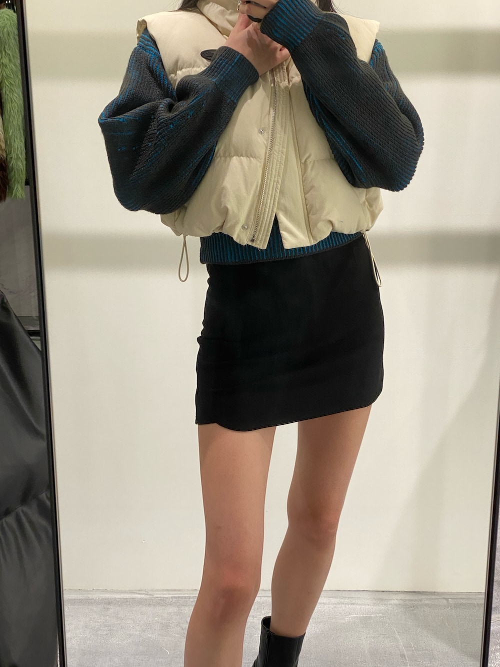 ブラック系のスカート、ブラック系のブーツ、ブルー系のニット/セーターを着用したレディースの秋コーディネートの2枚目の写真