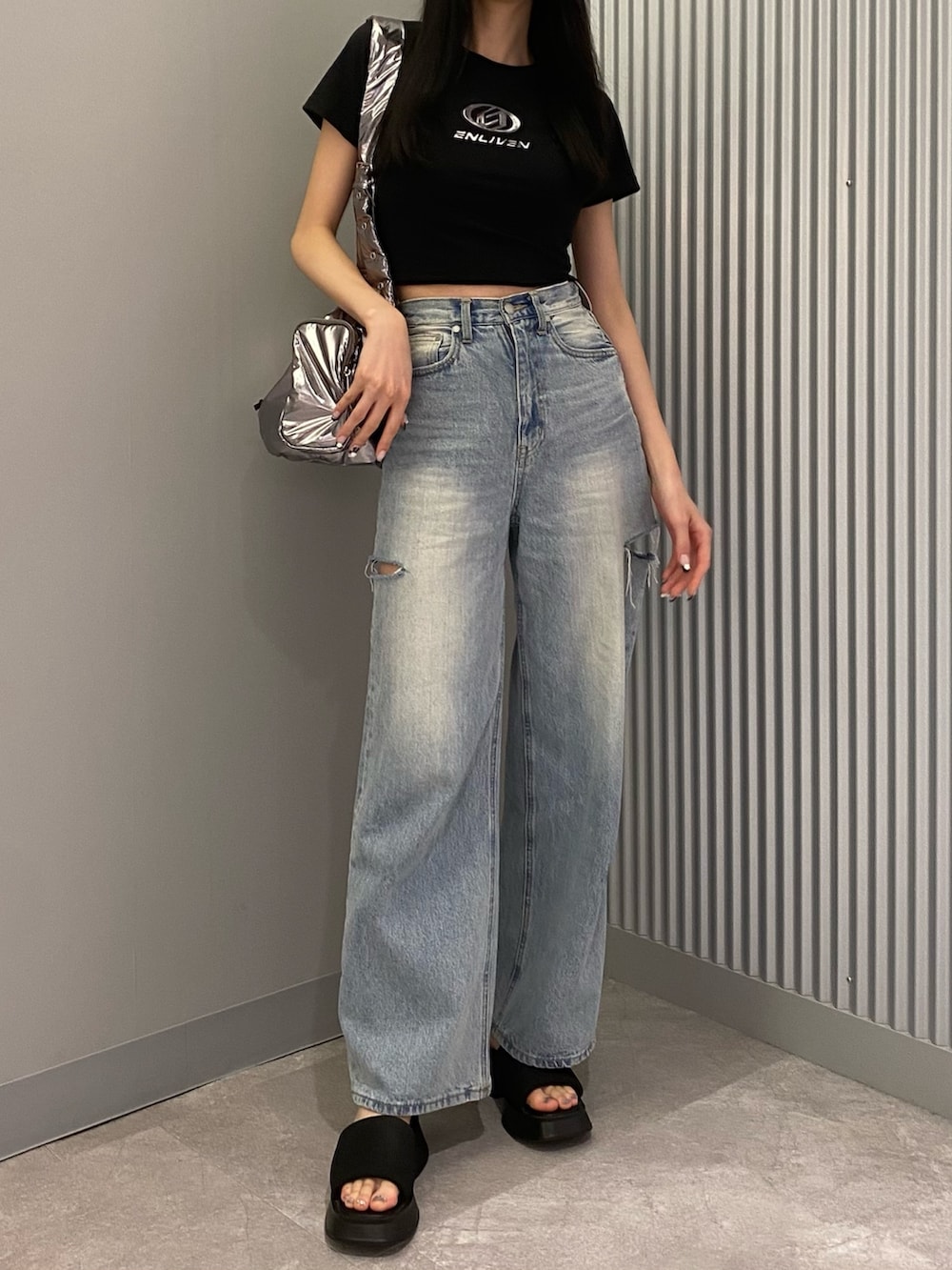 ブラック系のTシャツ/カットソー、ブラック系のサンダル、ブルー系のデニムパンツを着用したレディースの夏コーディネートの4枚目の写真