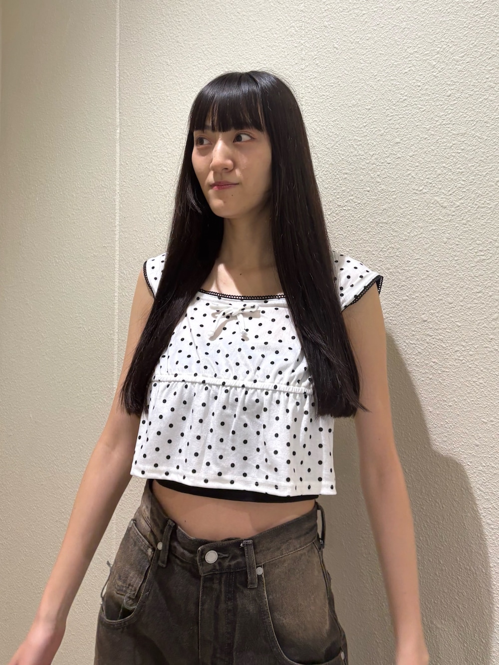 ブラック系のデニムパンツ、ホワイト系のタンクトップ、ブラック系のTシャツ/カットソーを着用したレディースの夏コーディネートの6枚目の写真
